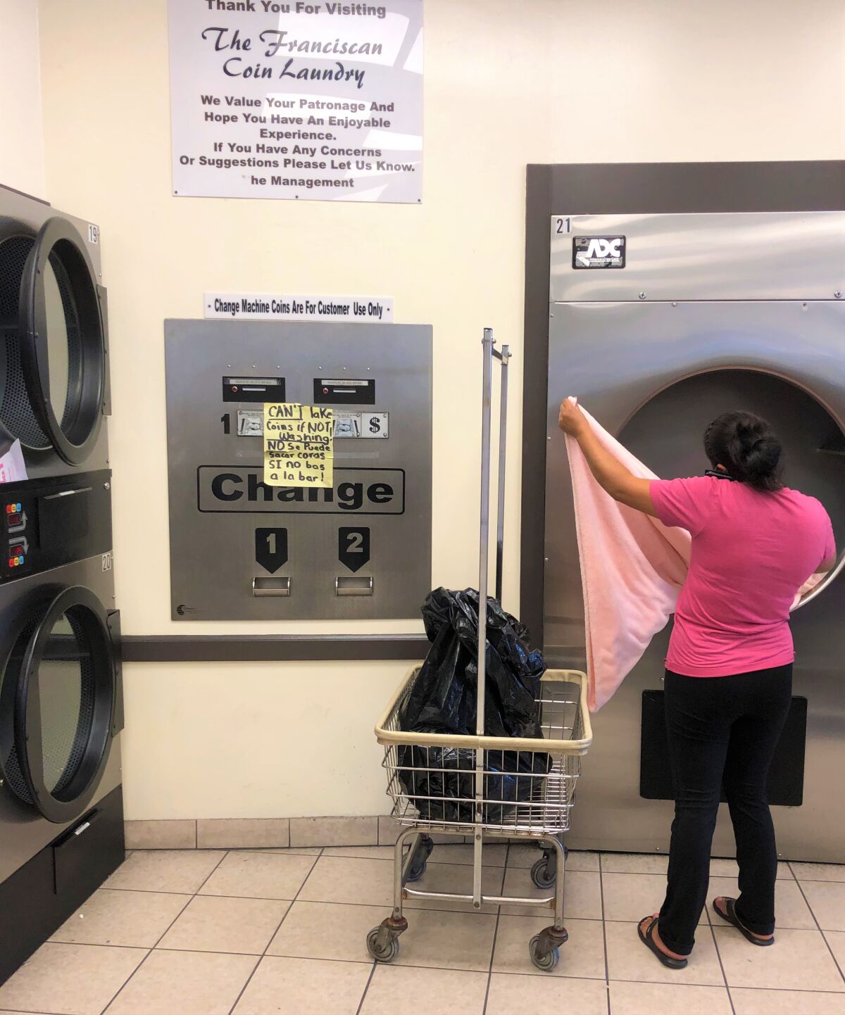 Customer folds laundry at The Franciscan Coin Laundry in Vista