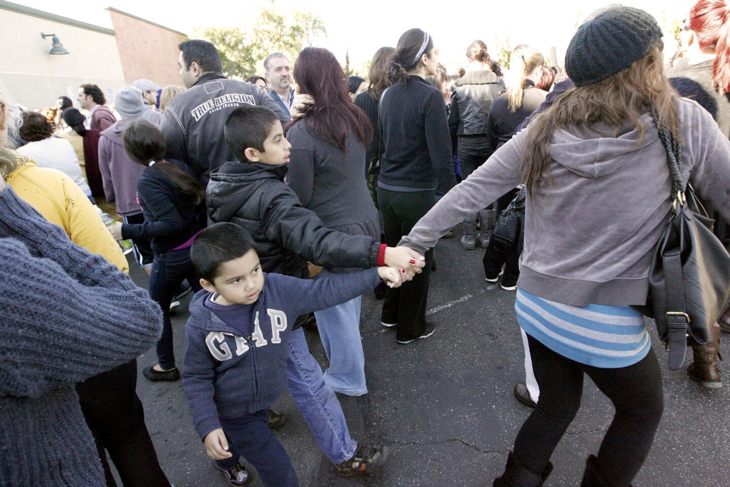 A parent leads her children away from an pickup area after R.D White Elementary School was evacuated due to a bomb threat on Monday, January 7, 2013.