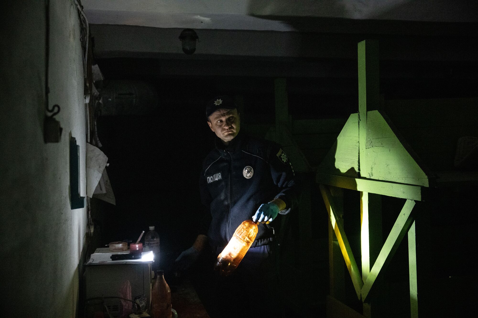 Uniformed man holding a light in a dark room 
