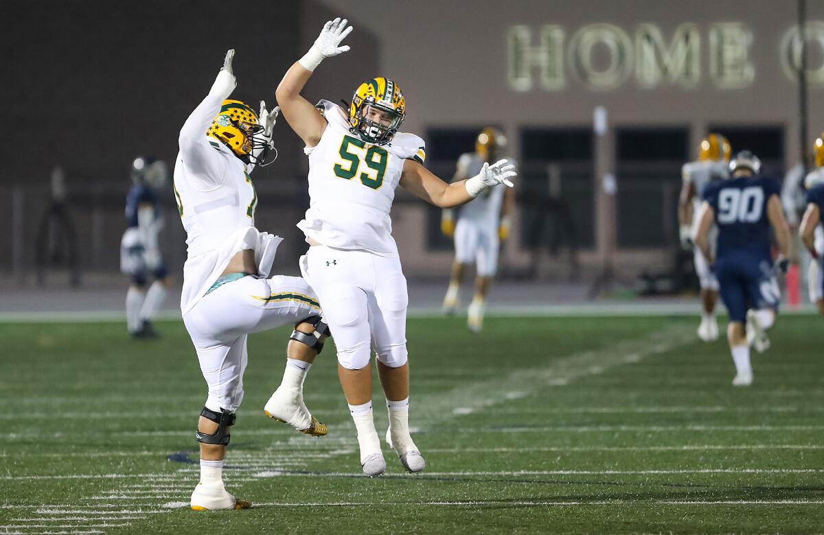 Edison linemen Nathan Gates and Luke Jones (59) celebrate a long catch and run for a touchdown against Newport Harbor.