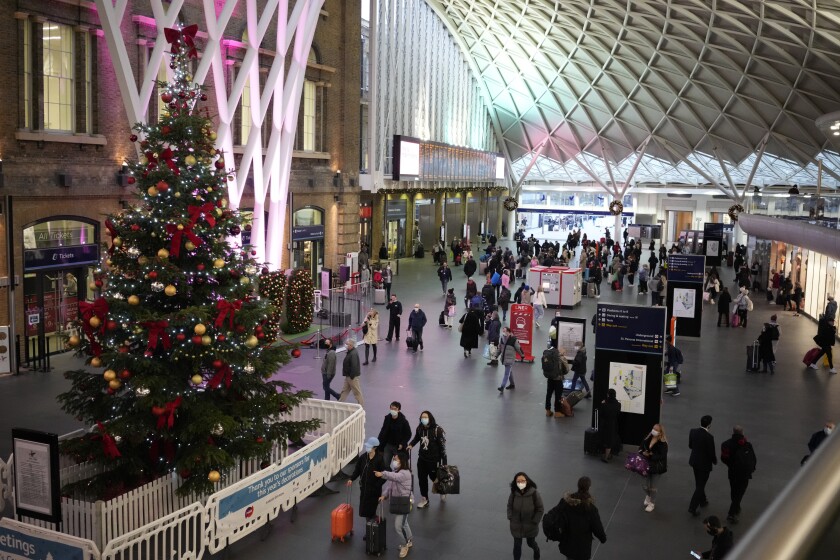 People walk past a Christmas tree in King's Cross train station, in London, the Eurostar hub to travel to European countries including France, Friday, Dec. 17, 2021. After the U.K. recorded its highest number of confirmed new COVID-19 infections since the pandemic began, France announced Thursday that it would tighten entry rules for those coming from Britain. Hours later, the country set another record, with a further 88,376 confirmed COVID-19 cases reported Thursday, almost 10,000 more than the day before. (AP Photo/Matt Dunham)
