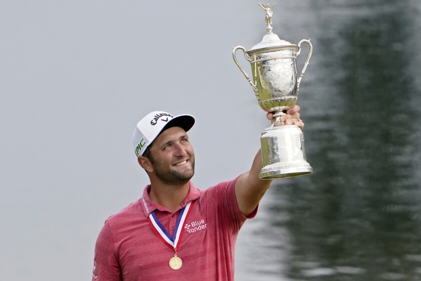 FILE - Jon Rahm, of Spain, holds the champions trophy for photographers after the final round of the U.S. Open Golf Championship, on June 20, 2021, at Torrey Pines Golf Course in San Diego. The world No. 1 returns to the site of his U.S. Open victory this week for the Farmers Insurance Open, a tournament he has also won before. (AP Photo/Jae C. Hong, File)