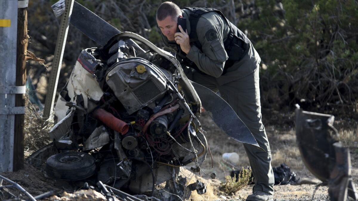 A San Bernardino County sheriff's pilot looks over the debris from a fatal plane crash near Hesperia Airport on Friday.