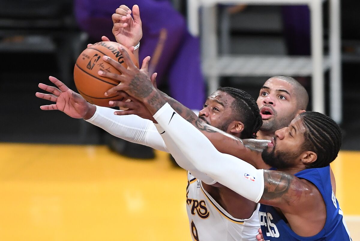 The Lakers' Wes Matthews battles the Clippers' Paul George, right, and is fouled by Nicolas Batum, back, on Dec. 11, 2020. 