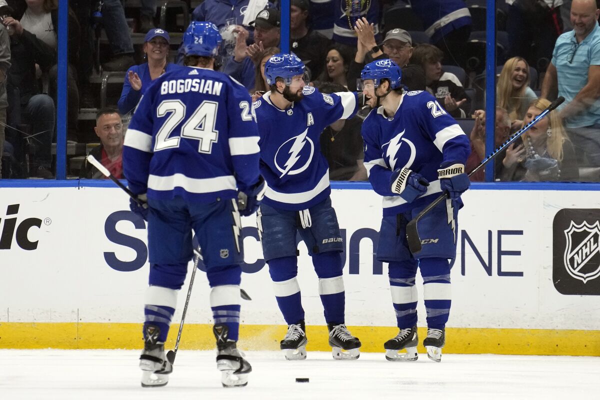 The Lightning's Brayden Point, right, celebrates his goal with Nikita Kucherov, middle, and Zach Bogosian on Jan. 28, 2023.