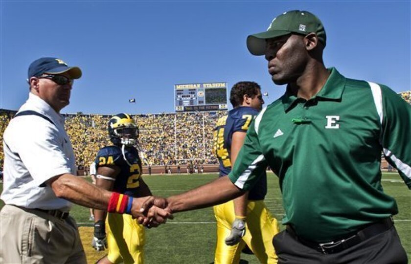 FILE- In this Sept. 19, 2009, file photo, Michigan head coach Rich Rodriguez, left, shakes hands with Eastern Michigan head coach Ron English after an NCAA college football game in Ann Arbor, Mich. English coached under former Michigan head coach Lloyd Carr as the defensive coordinator until Carr's retirement in 2007. (AP Photo/Tony Ding)