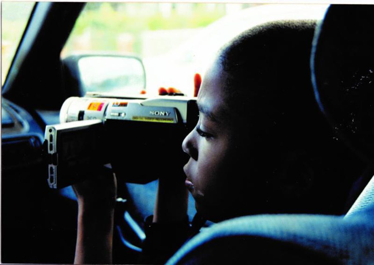 A young boy in a car uses a video camera in the documentary "17 Blocks."
