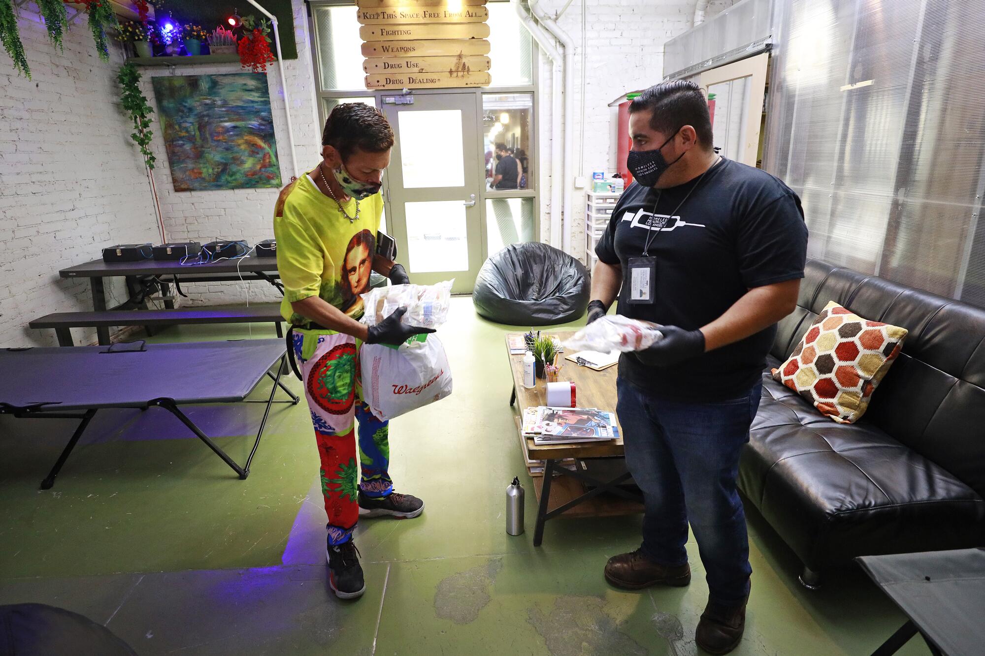 Diamond Mendoza, left, receives healthcare items from Christian Diaz at the Center for Harm Reduction drop-in center