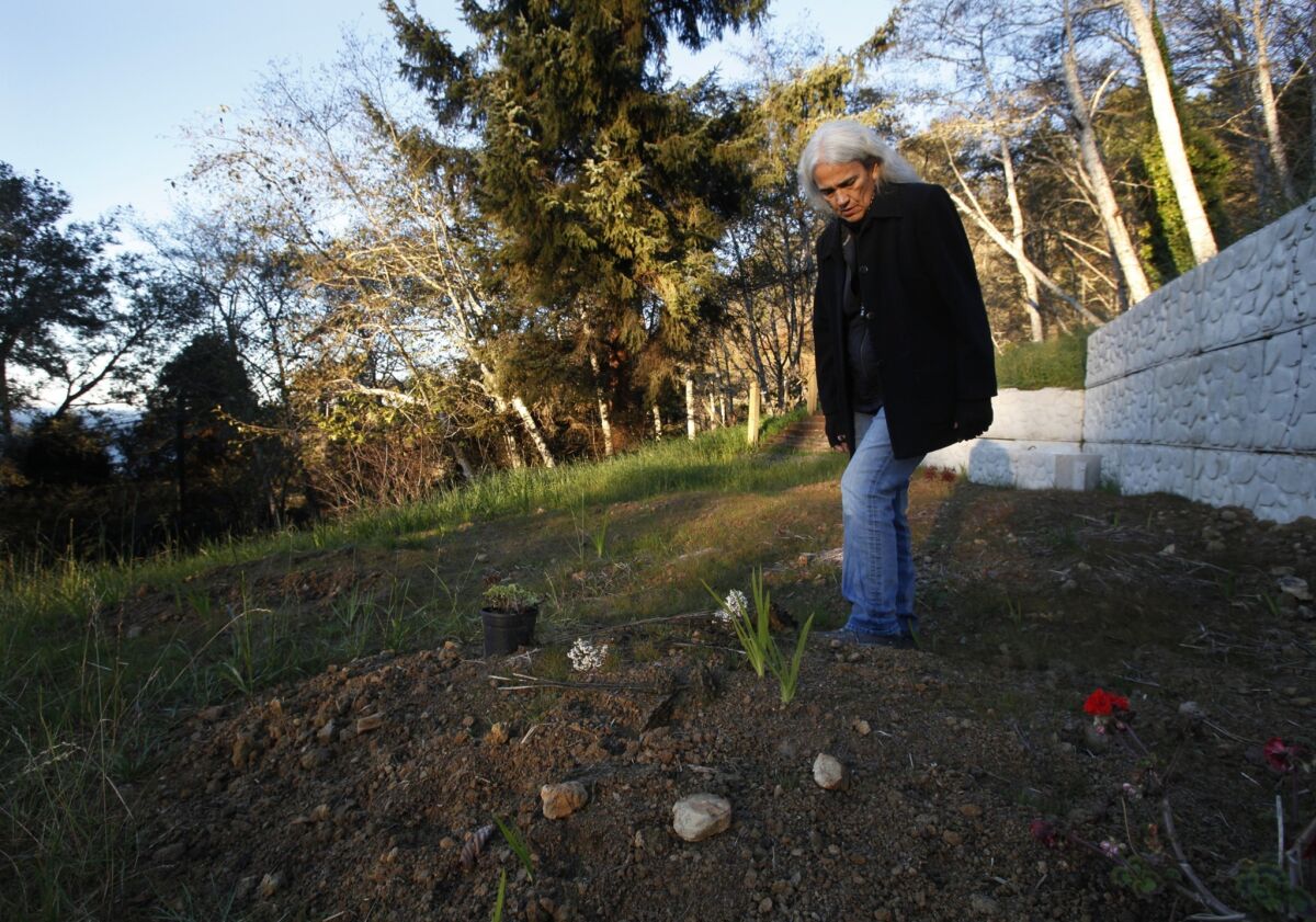 As the sun rises, Abinanti places flowers on her mother's grave next to her home at the mouth of the Klamath River along California's north coast. Abinanti visits the grave, now on her tribal land, before going to work.
