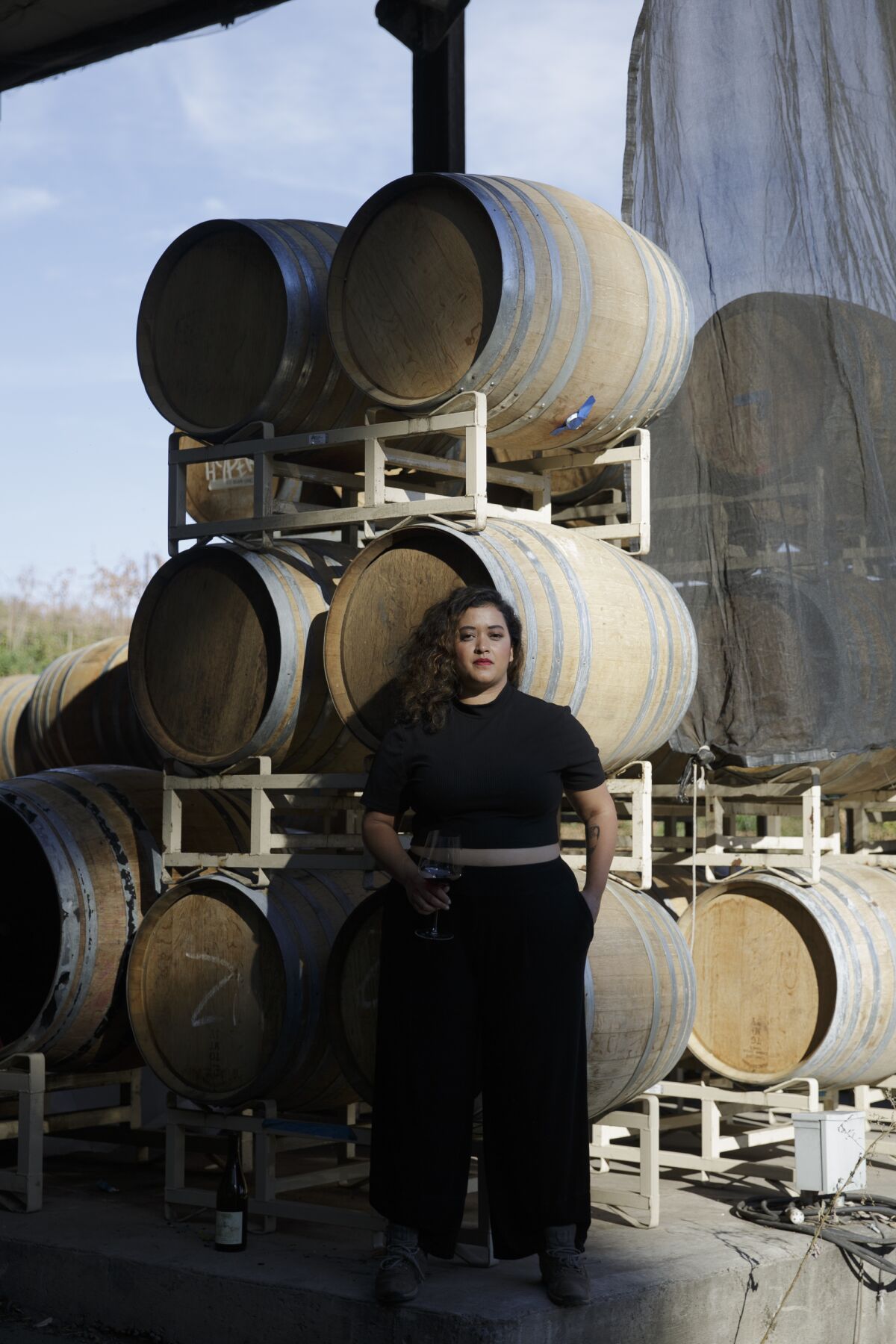 Jirka Jireh stands in front of barrels of wine.