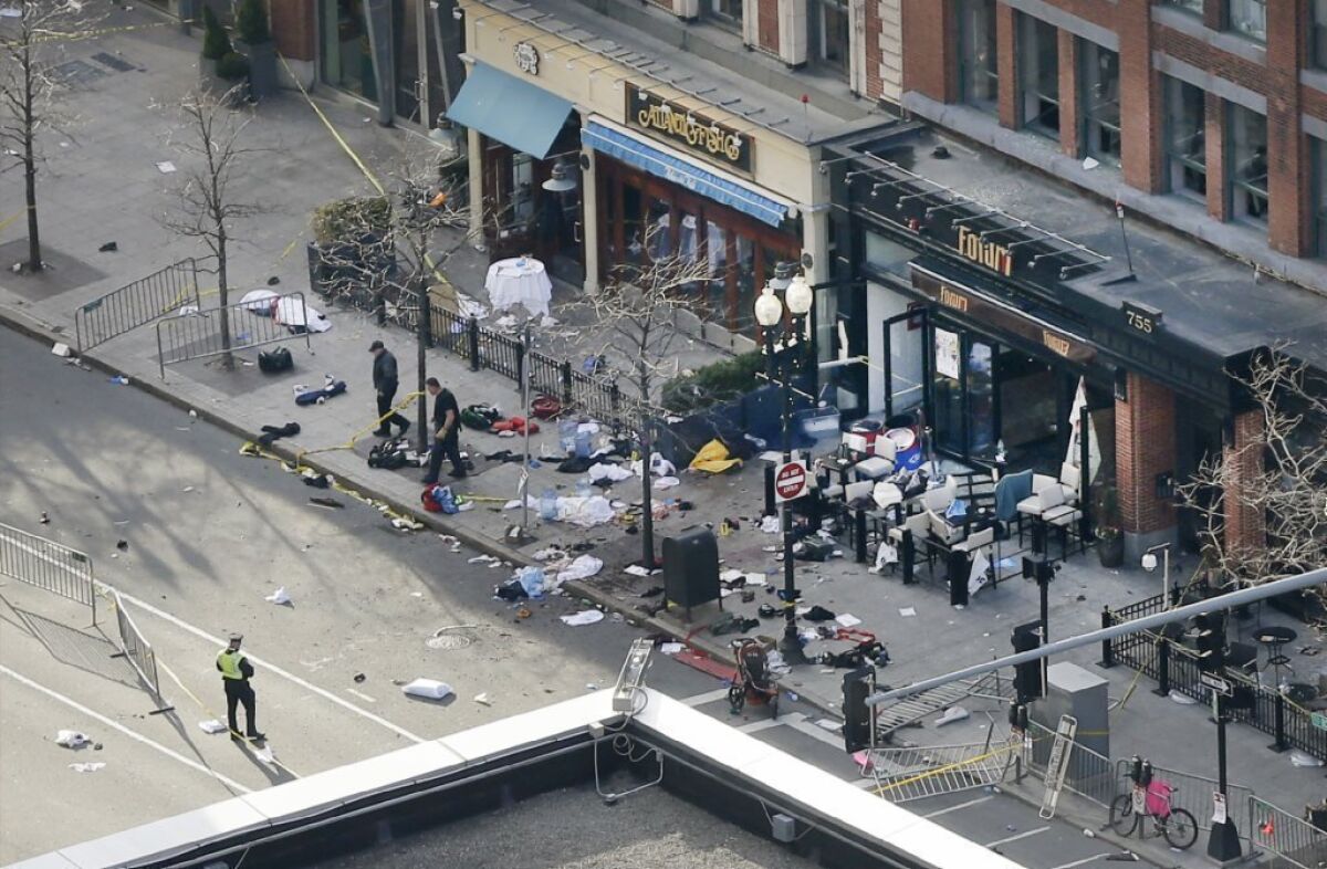 One of the blast sites on Boylston Street near the finish line of the Boston Marathon is investigated and guarded by police.