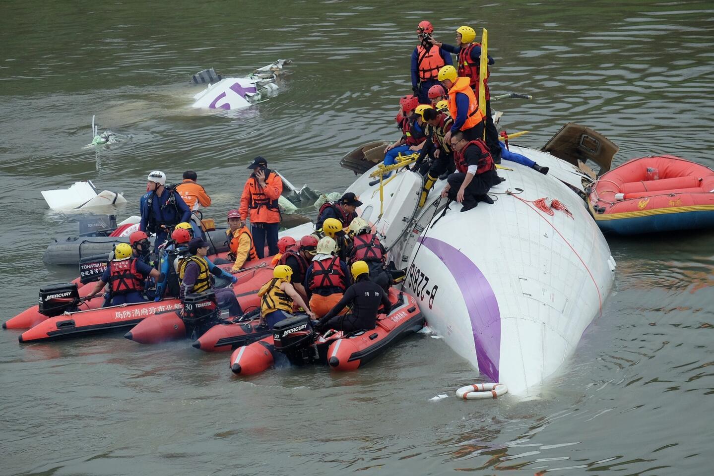 Rescue personnel work to free passengers from a TransAsia ATR 72-600 turboprop plane that crash-landed into a river outside Taiwan's capital, Taipei.