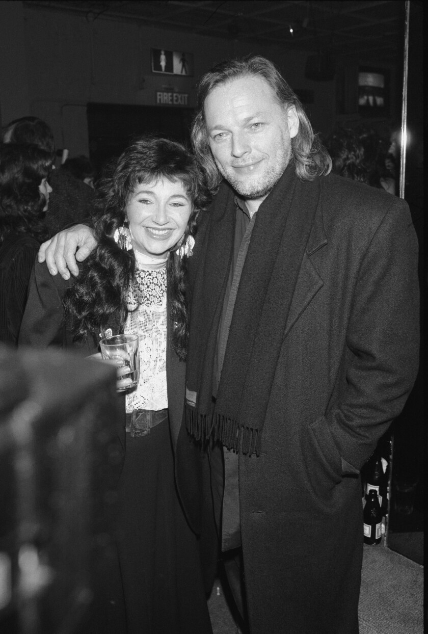 A man puts his arm around a woman and poses for a photograph 