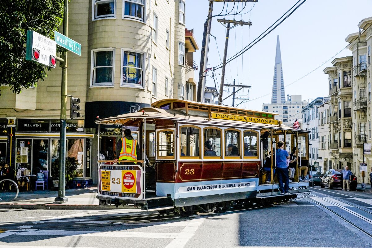 A cable car turns a corner on a San Francisco street