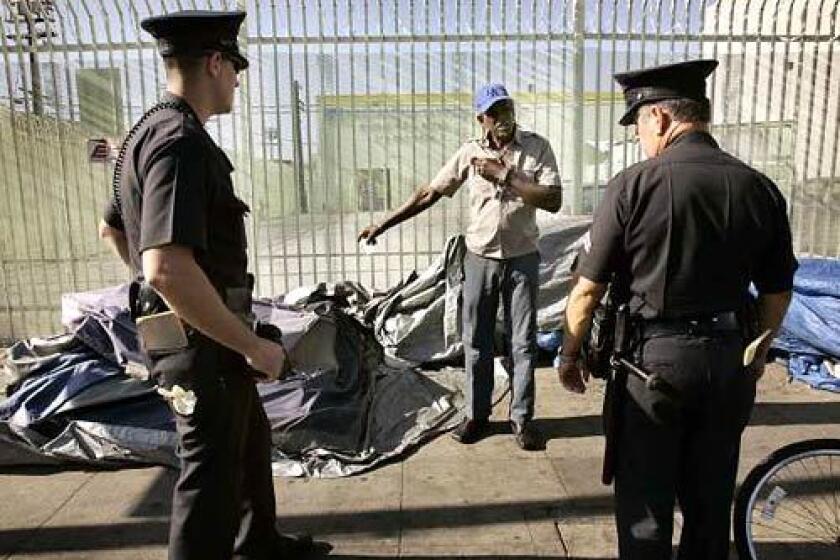 WARNING: LAPD Officers Mike Coblentz, left, and Guadalupe Shep Ruvalcaba tell 58-year-old Tyrone Victor Valiant that he needs to reduce the sidewalk space taken up by his tent on 6th Street.