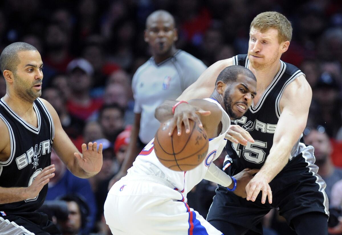 Clippers point guard Chris Paul tries to control his dribble while he is double-teamed by Spurs guard Tony Parker and forward Matt Bonner in the first half.