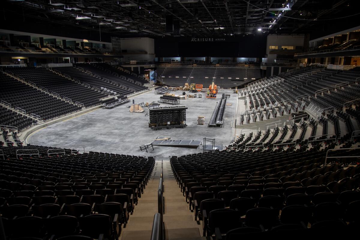 The inside of an arena with construction vehicles in the center.