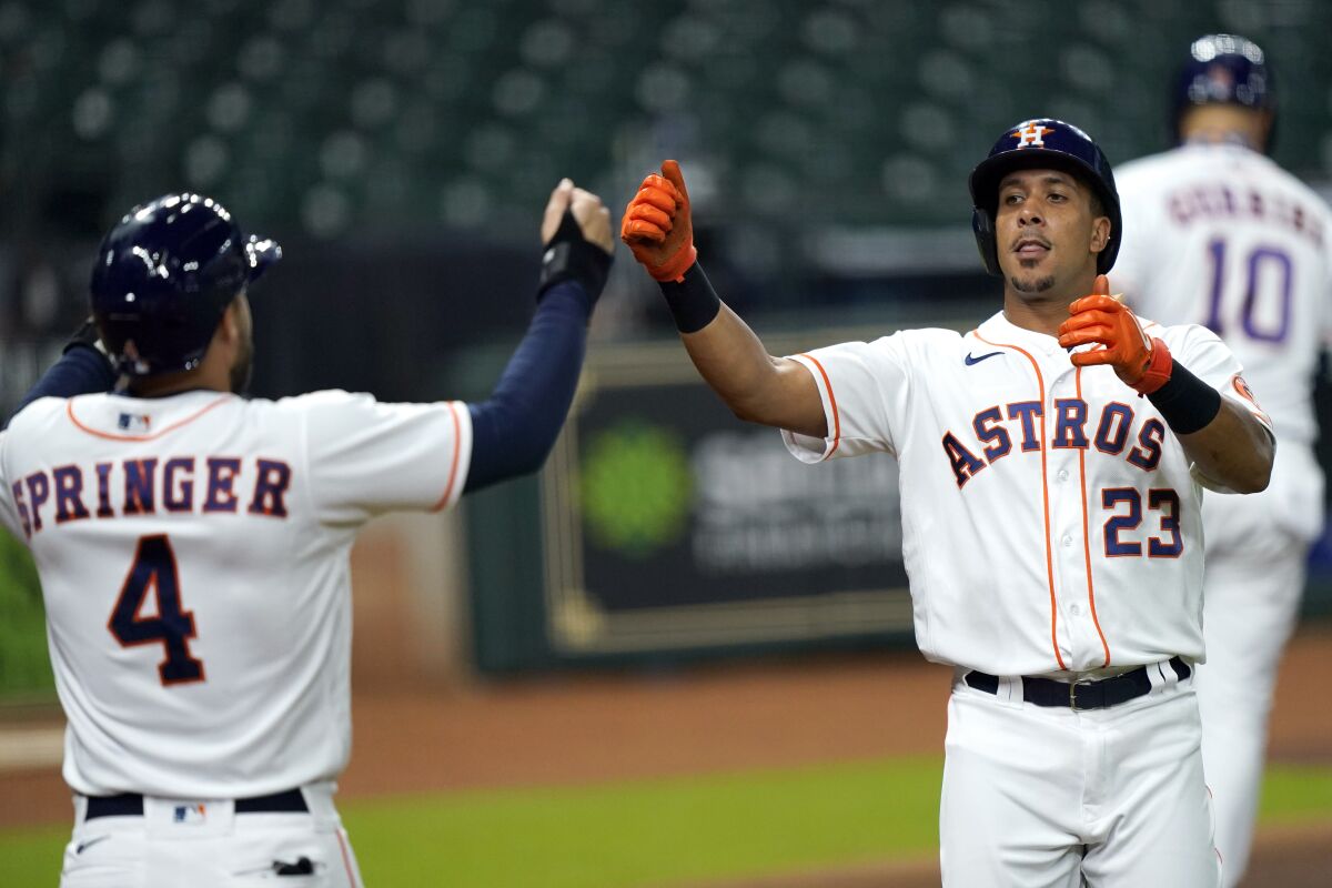 Houston Astros' Michael Brantley (23) celebrates with George Springer (4) after hitting a home run against the Texas Rangers during the first inning of a baseball game Wednesday, Sept. 2, 2020, in Houston. (AP Photo/David J. Phillip)