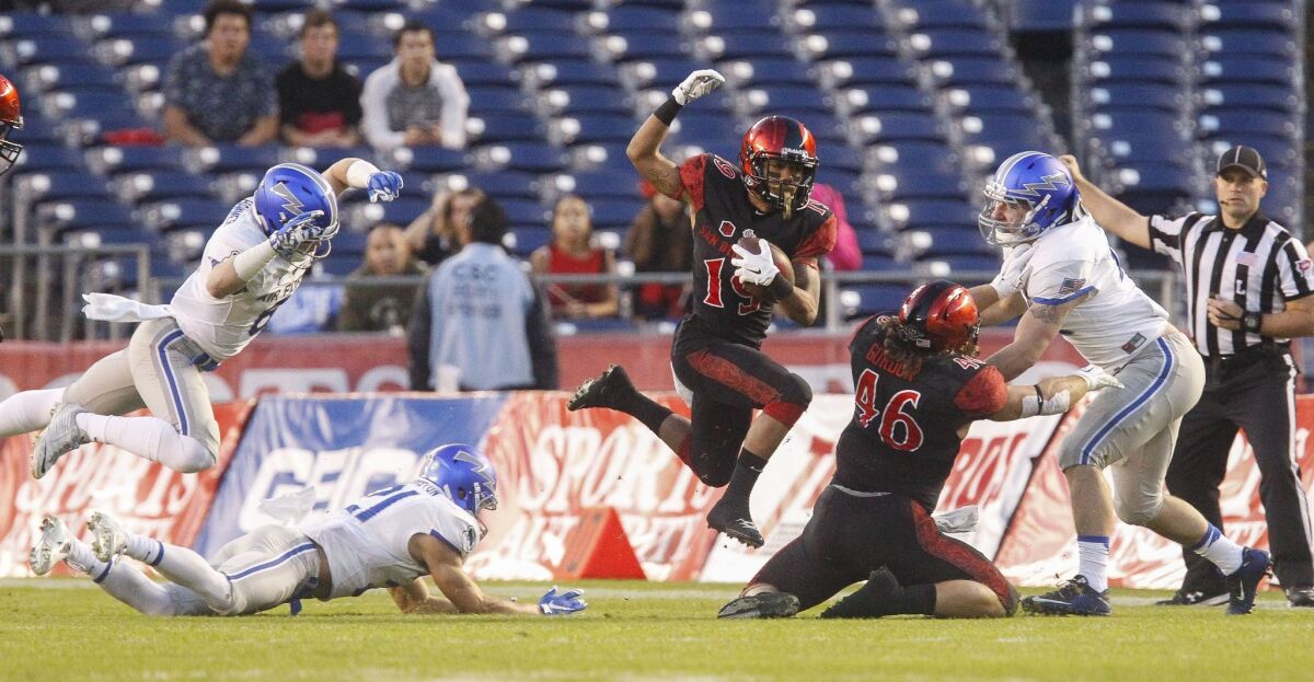 The Aztecs' D.J. Pumphrey makes a hop as he carries the ball during the first quarter of the Aztecs game against Air Force at Qualcomm Stadium in San Diego on Saturday.