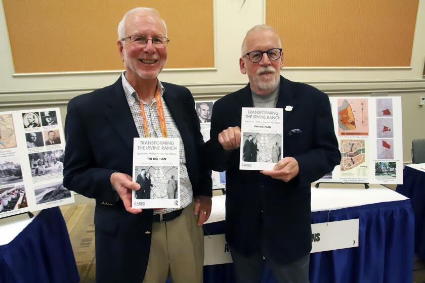 Michael Stockstill, left, and Pike Oliver pose with their new book Transforming The Irvine Ranch during the American Planning Association California Chapter Convention at the Marriott Hotel Orange County Ballroom at the Anaheim Convention Center in Anaheim on Sunday, October 2, 2022. (Photo by James Carbone)