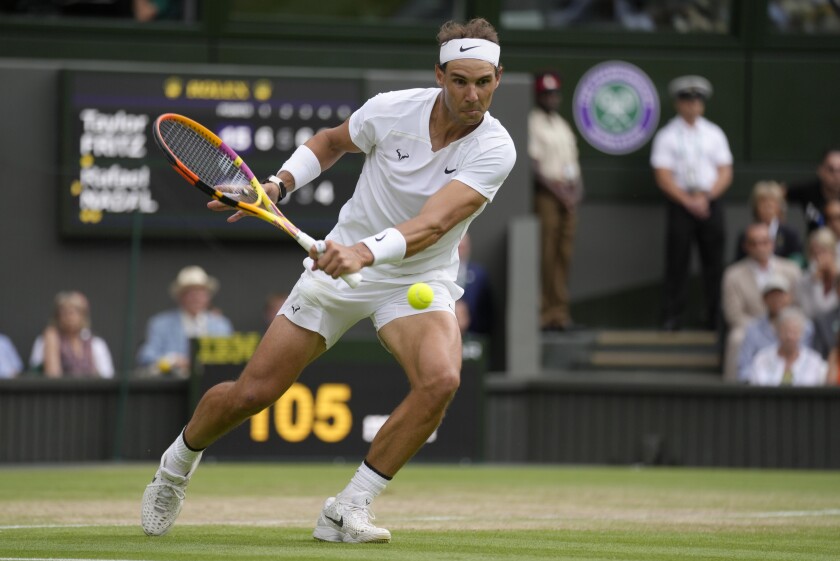 Spain's Rafael Nadal returns to Taylor Fritz of the US in a men's singles quarterfinal match on day ten of the Wimbledon tennis championships in London, Wednesday, July 6, 2022. (AP Photo/Kirsty Wigglesworth)
