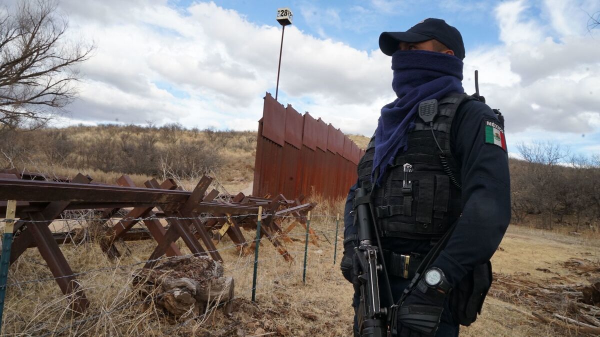 Donde termina la cerca de acero de 15 pies, en la frontera entre Arizona y México, comienza una barrera hecha de viejas vías de tren y alambre de púas. La policía de Nogales, México, a menudo responde a incidentes a lo largo de ese tramo (Liliana Nieto del Río / para The Times).