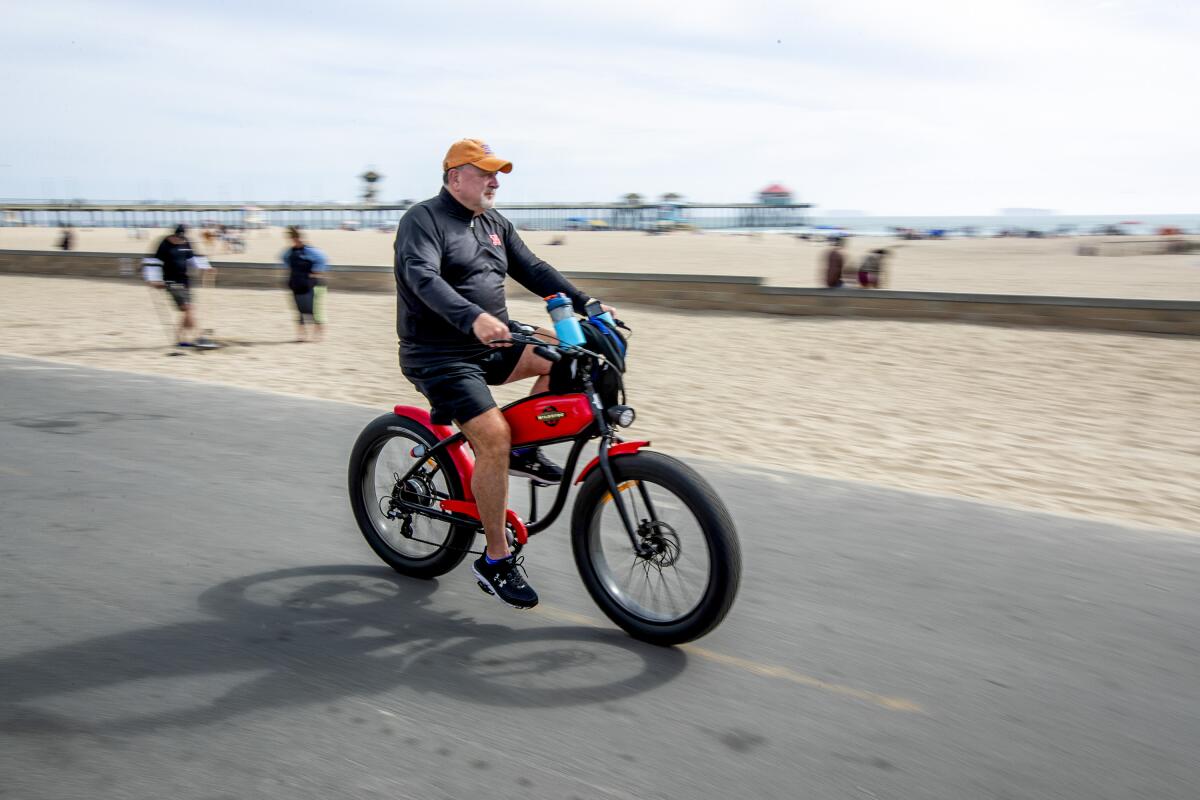 A man rides an e-bike on the bike path in Huntington Beach on Wednesday, April 7.