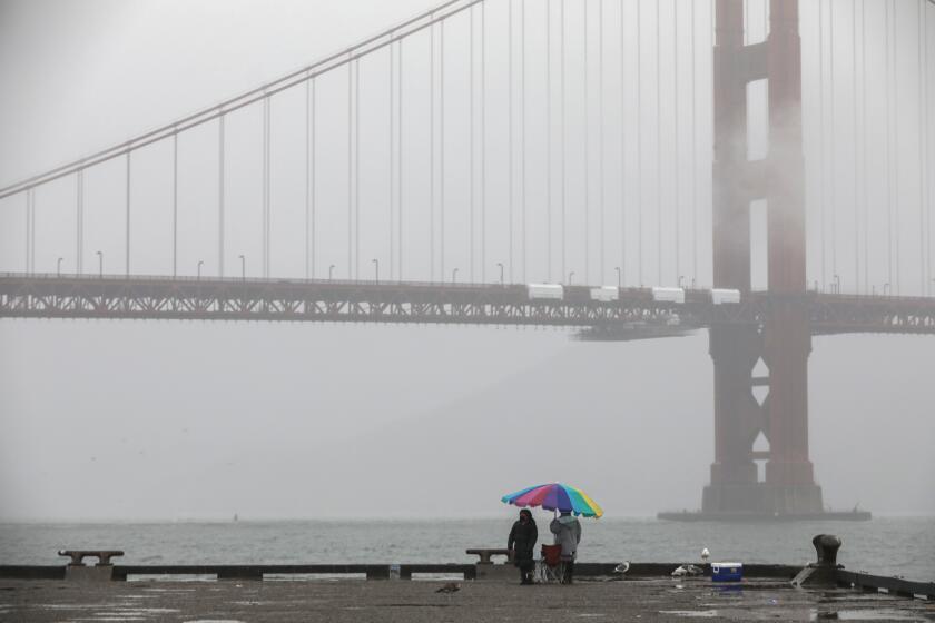A misty view of the Golden Gate Bridge can be seen from Torpedo Wharf at Fort Point in San Francisco,
