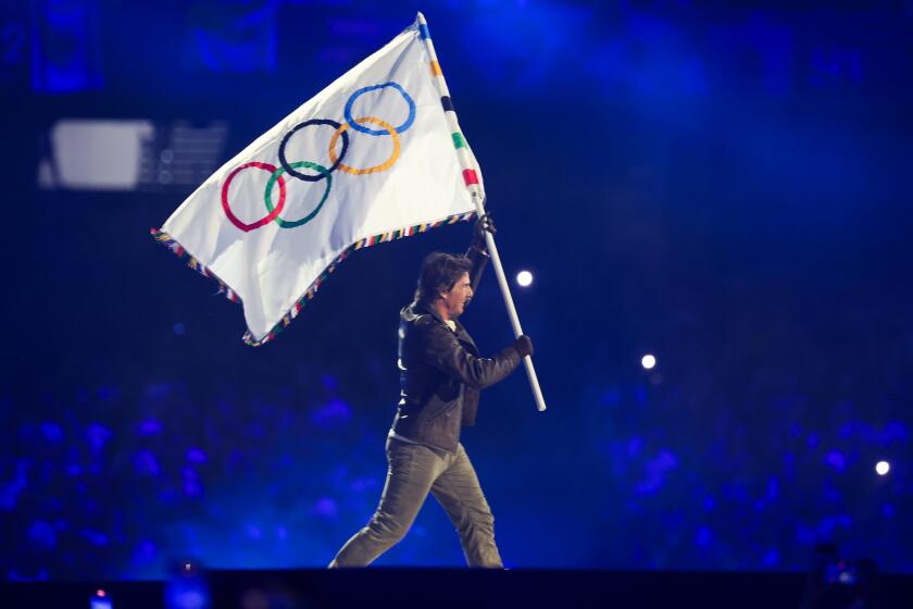 PARIS, FRANCE - AUGUST 11: Tom Cruise bears the Olympic flag during the closing ceremony of the 2024 Paris Olympics at Stade de France on Sunday, August 11, 2024 in Paris, France. (Wally Skalij / Los Angeles Times)