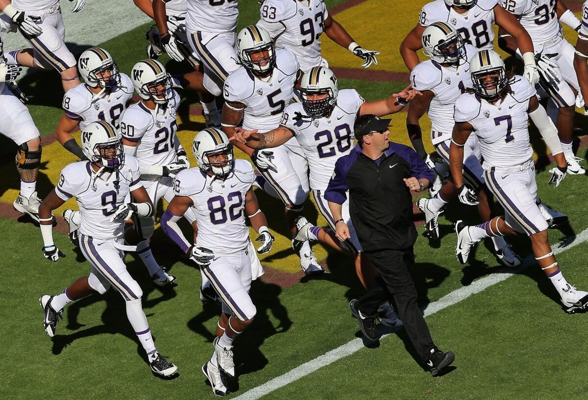 Steve Sarkisian, USC's newly named football coach, met with Trojans players Monday night. Above, he is shown leading the Washington Huskies onto the field in October to face Arizona State.