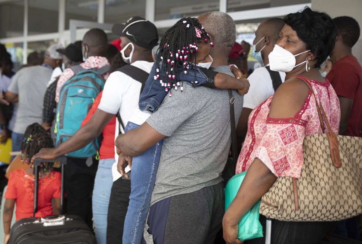 Haitian migrants wait in line to check-in for a flight to Chile, at the Toussaint Louverture International Airport, in Port-au-Prince, Haiti, Sunday, Jan. 30, 2022. Thousands of Haitians in recent months have boarded charter flights to South America, according to flight tracking information and independent verification by The Associated Press in collaboration with the University of California, Berkeley. (AP Photo/Odelyn Joseph)