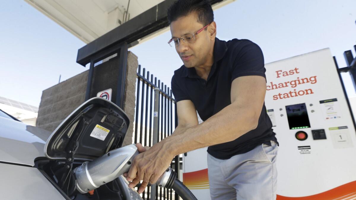 A man plugs a charger into his electric vehicle in Sacramento in 2015.