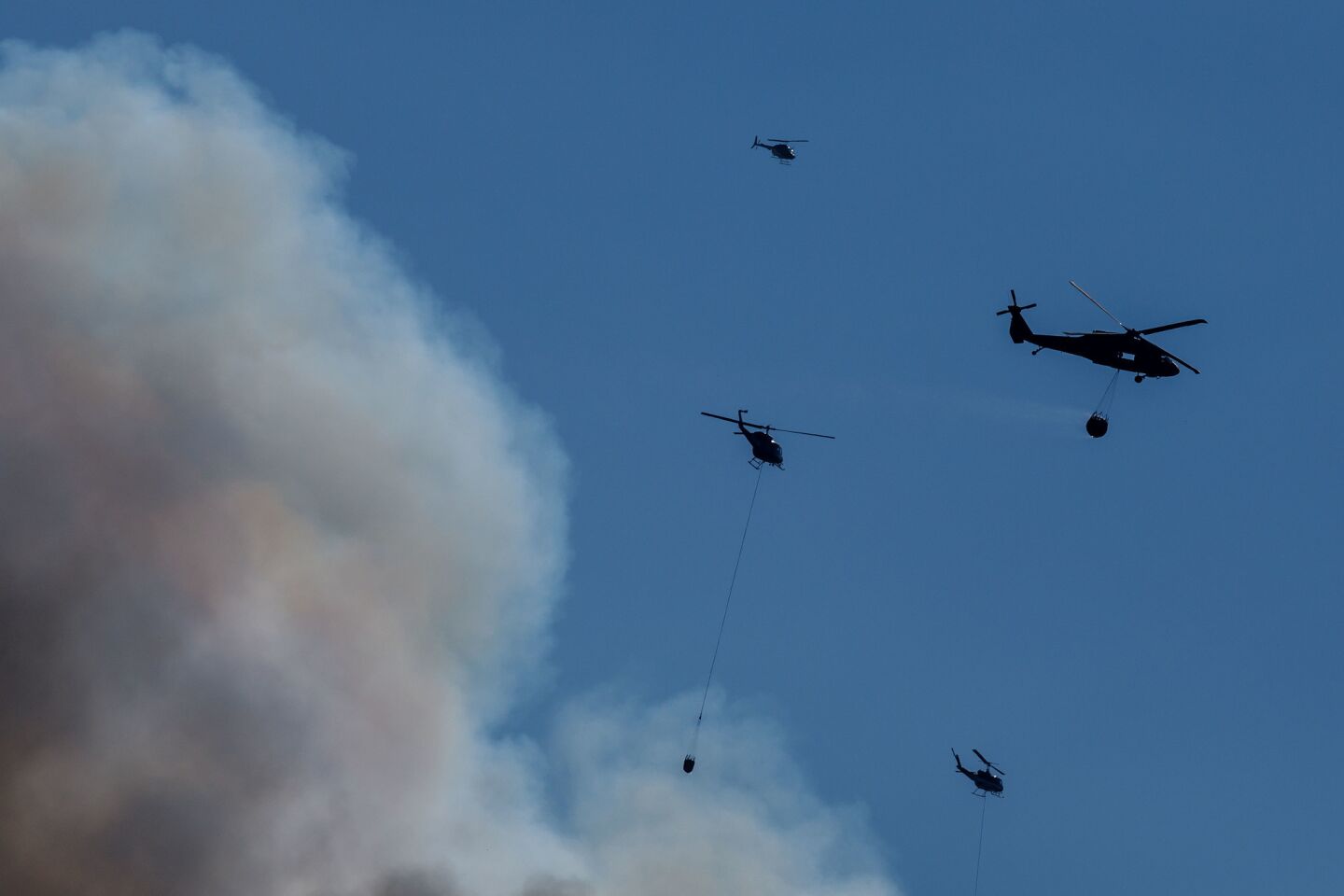 Helicopters make water drops as flames from the River fire advance towards Lakeport, Calif.