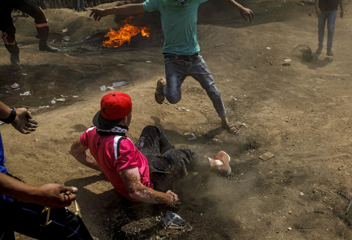 Wadieh Ras falls to the ground after getting shot by Israeli forces during a protest at the border fence between Gaza and Israel east of Gaza City.