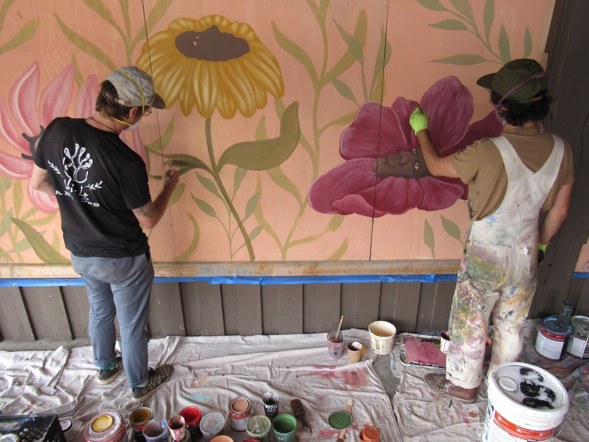 Aaron Glasson (left) and Jonny Alexander work on a mural together in the La Mesa Springs Shopping Center.