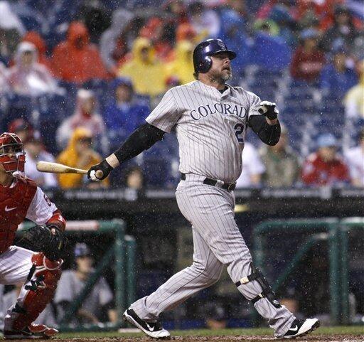 Colorado Rockies pinch hitter Jason Giambi (23) high fives teammate Todd  Helton after scoring against the Philadelphia Phillies in the eighth inning  during game four of the National League Divisional Series at