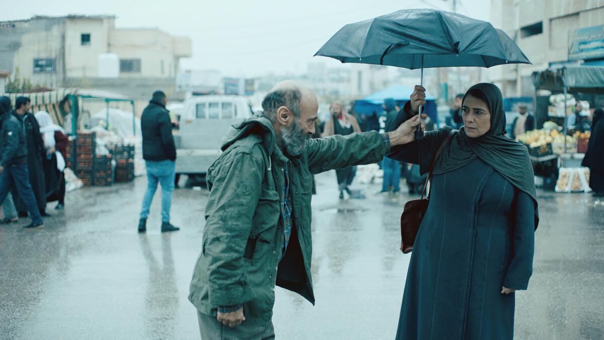 A man and a woman hold an umbrella in the movie “Gaza Mon Amour.”