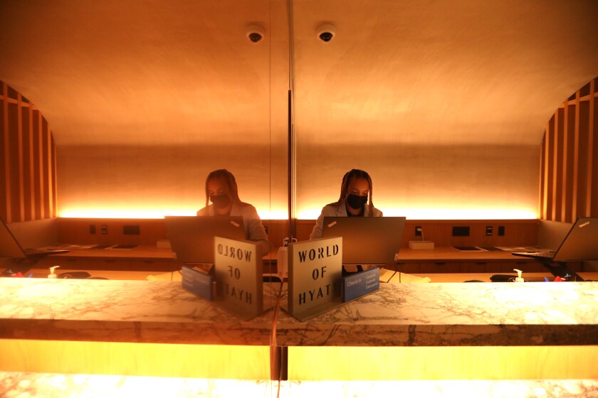 A woman works behind the front desk of a hotel.