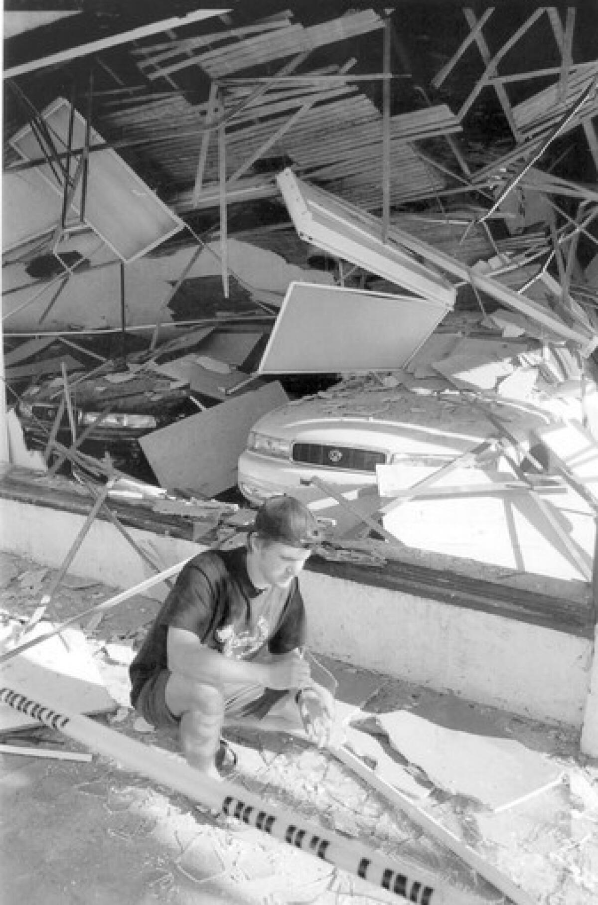 David Lane checks damage in front of a Mazda dealership in Santa Monica after the 1994 Northridge earthquake. Santa Monica adopted regulations on retrofitting vulnerable buildings, but its resolve has faded in recent years.