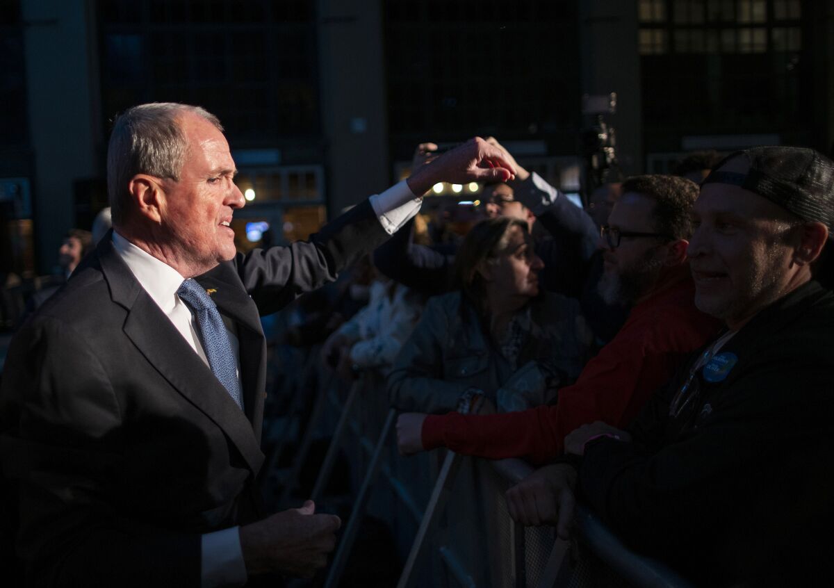 Phil Murphy reaches out to grasp a supporter's hand