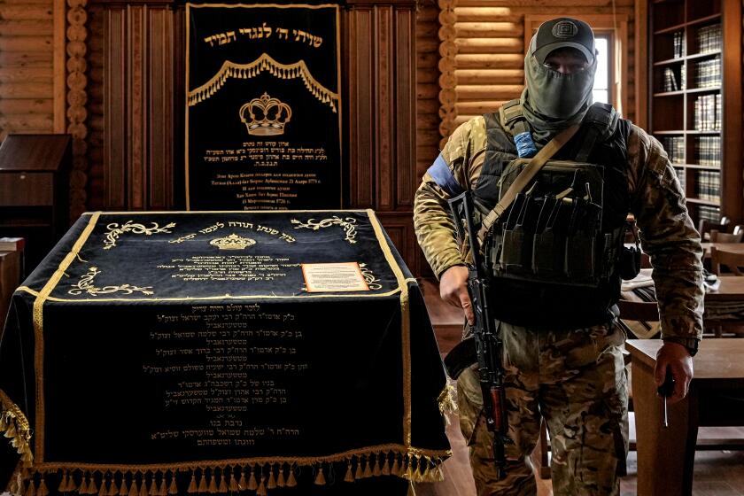 A member of the security team walks inside the synagogue at the Anatevka Jewish settlement outside Kyiv, Ukraine