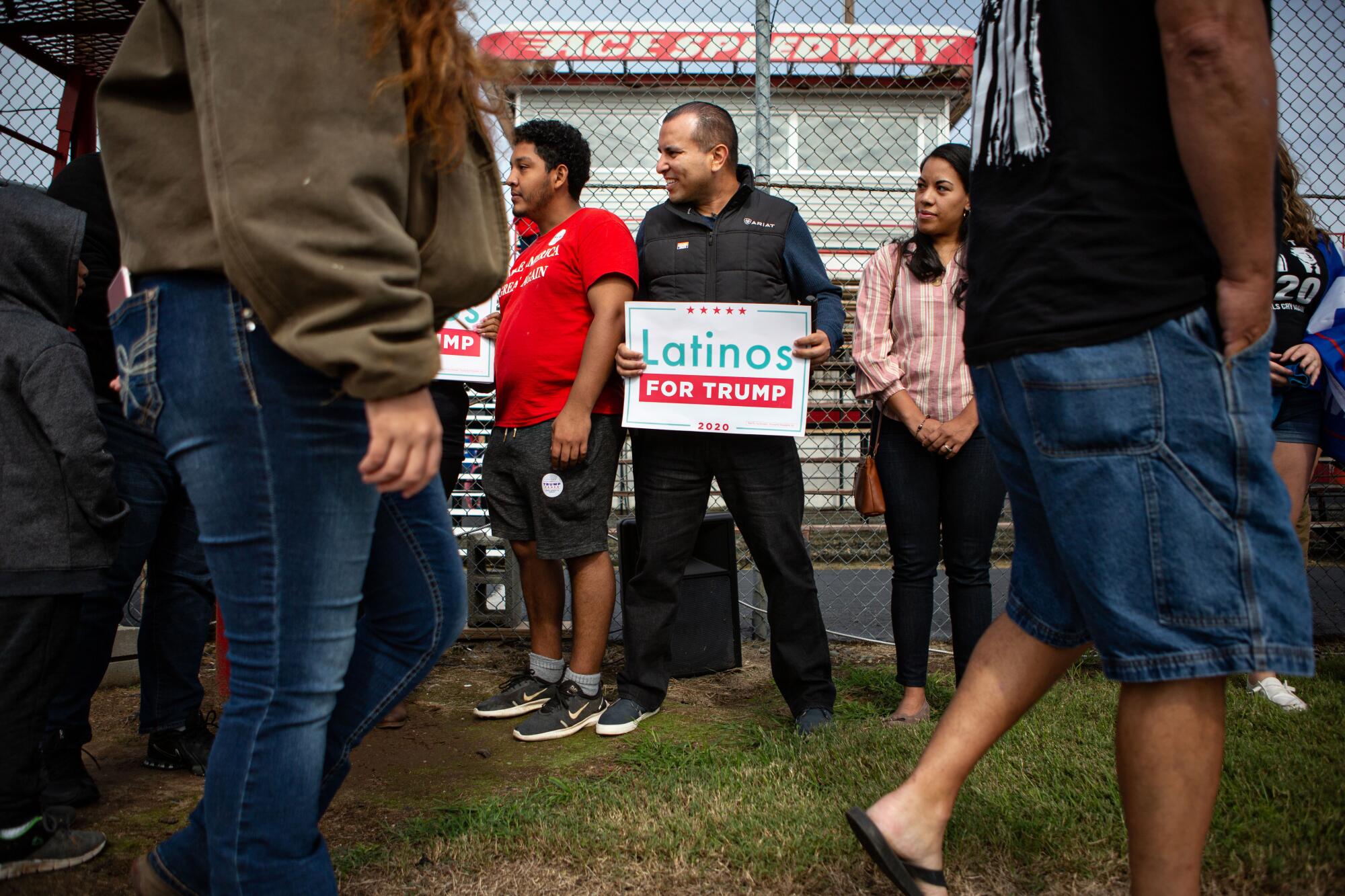 Omar Lugo, center, gathers with other Latino Trump supporters at Ace Speedway at a rally in Elon, N.C.