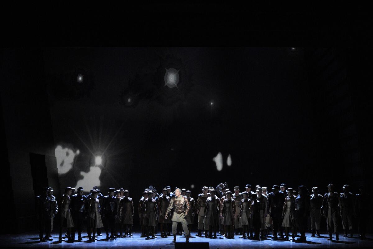Many people on a dark stage in an opera