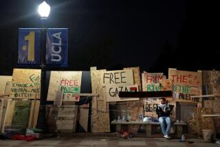 LOS ANGELES, CALIFORNIA - May 2: A pro-Palestinian protester sits on a bench after an oder to disperse was given by law enforcement at UCLA early Thursday morning. (Wally Skalij/Los Angeles Times)