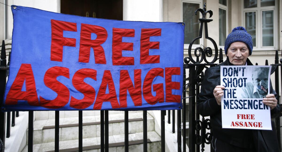 Un manifestante sostiene un cartel en el exterior de la emabaja de Ecuador en Londres, donde se refugia el fundador de Wikileaks Julian Assange, el 4 de febrero de 2016. (Foto AP/Kirsty Wigglesworth)