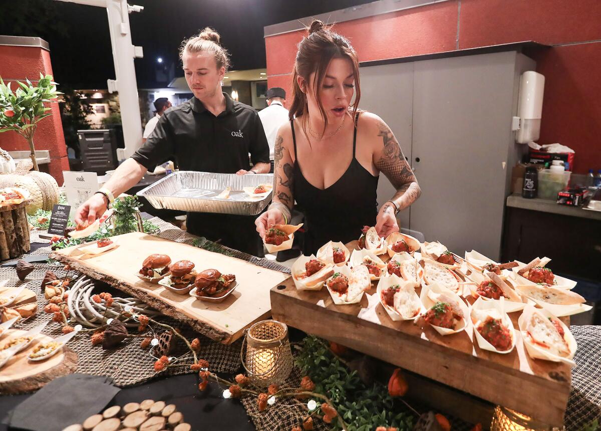 Dylan Smith and Kendra Smith organize sliders and meatballs from Oak Restaurant.