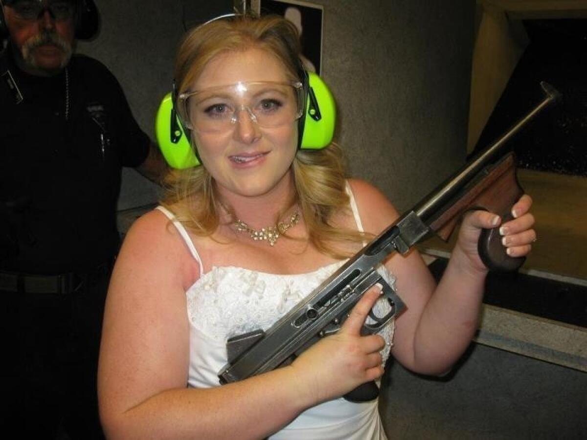 This July 28, 2012, photo provided by Bob MacDuff shows Lindsae MacDuff holding an automatic weapon at the Gun Store in Las Vegas after her "shotgun wedding."