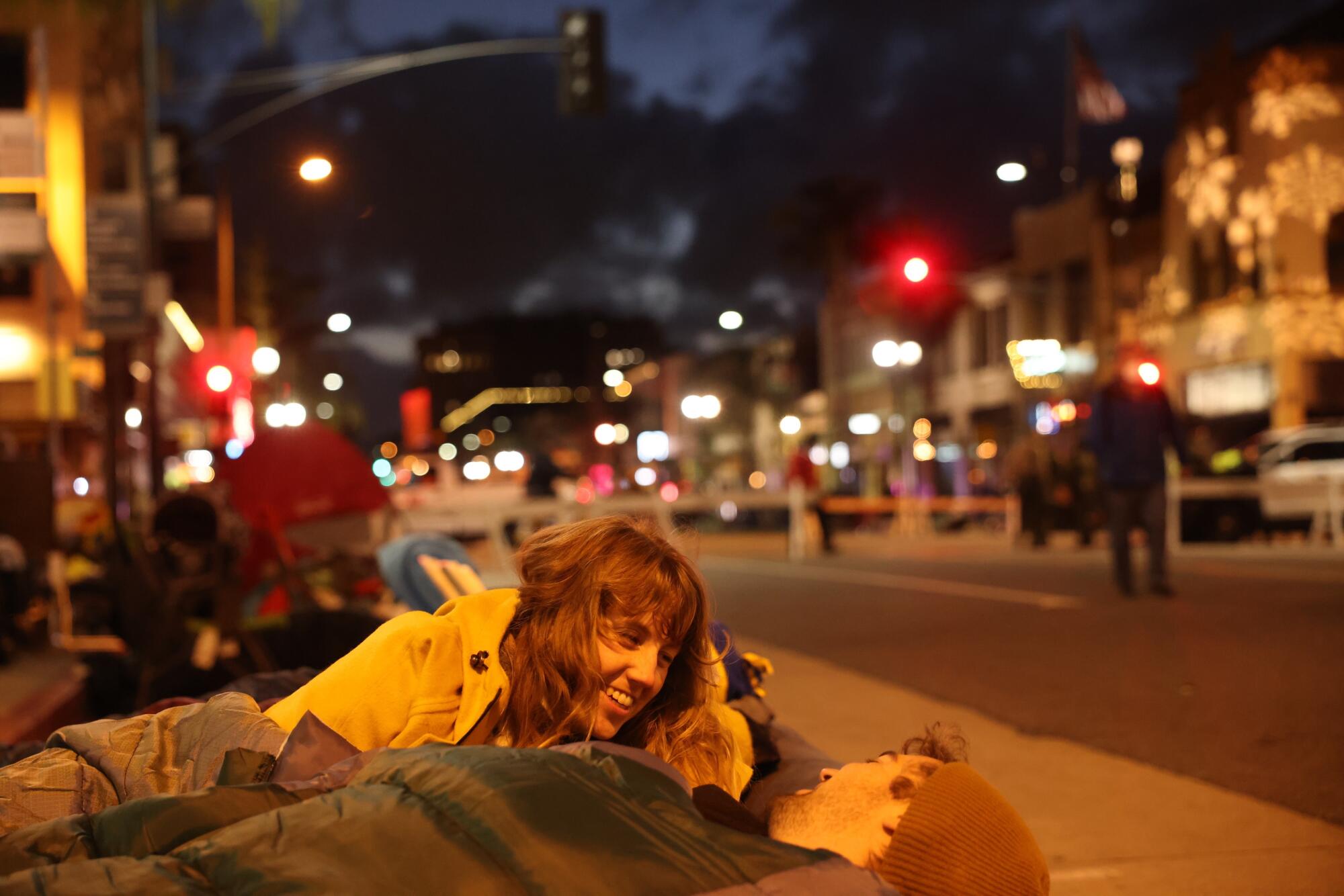 A woman wakes up along the Rose Parade route next to a man.
