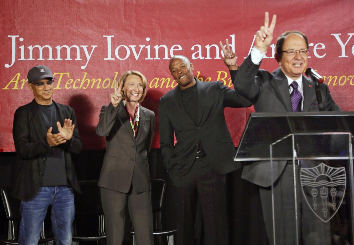 Erica Muhl, dean of the USC Roski School of Fine Arts (center) appears with Jimmy Iovine, the co-founder of Interscope Records, left, and rapper Dr. Dre at the opening of the pair's new namesake academy at the university.