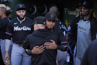 El venezolano Luis Arráez abraza a un empleado de los Marlins de Miami, tras una negociación que lo enviaría en canje a los Padres de San Diego, el viernes 3 de mayo de 2024, en Oakland (AP Foto/Godofredo A. Vásquez)